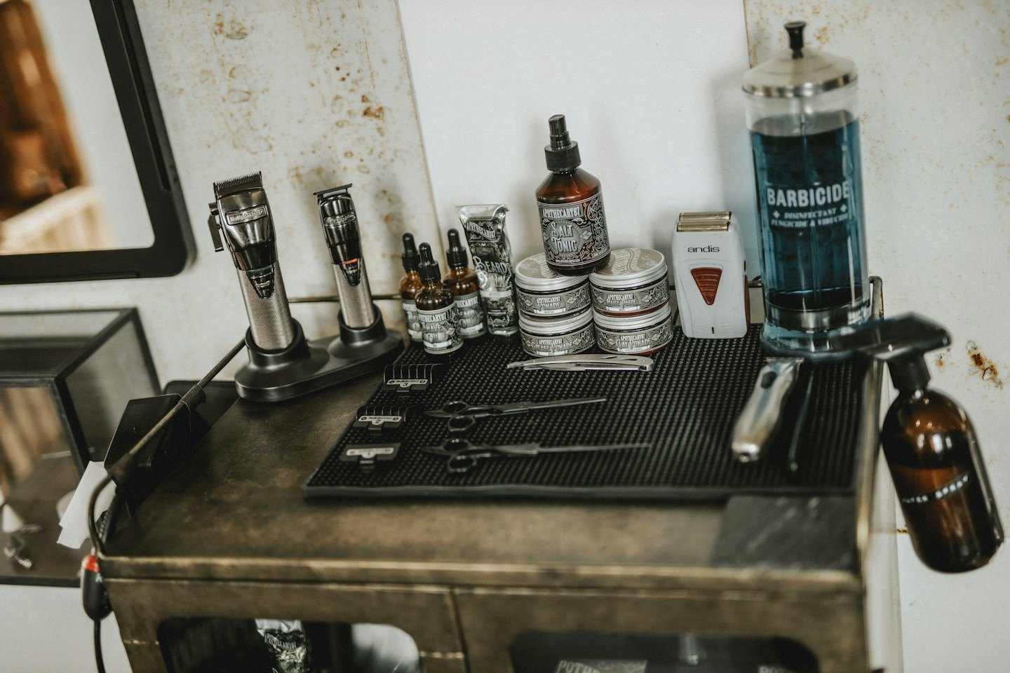 Professional grooming tools arranged on a barber workstation cabinet.